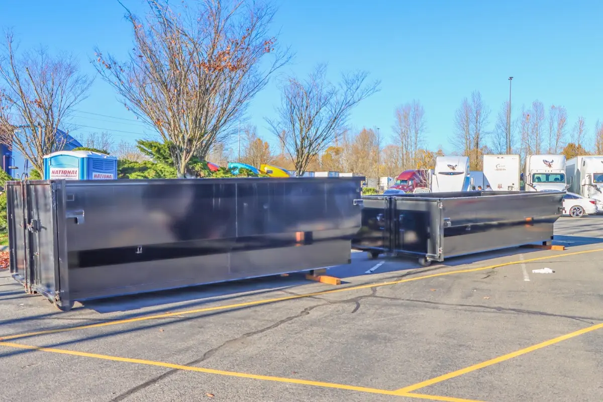 Professional dumpster rental service with roll-off container on residential driveway in Tiverton